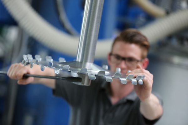 Mitarbeiter von Dreisol Coatings arbeitet an einer Maschine – professionelle Lackbehandlung und Fertigung in der Produktion