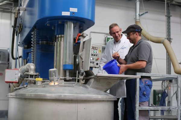 Mitarbeiter von Dreisol Coatings arbeitet vor einer Maschine – professionelle Anwendung von Papierlacken in der Produktion